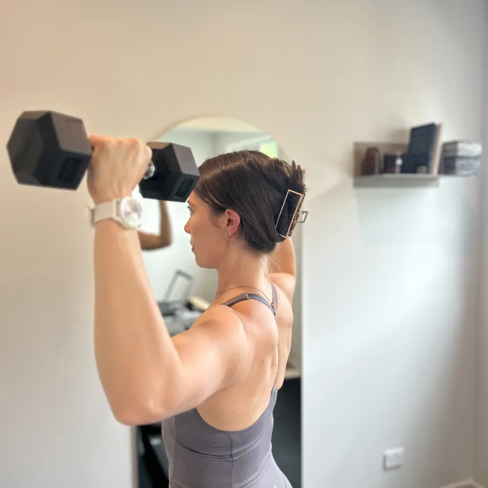 Shoulder press in front of the mirror