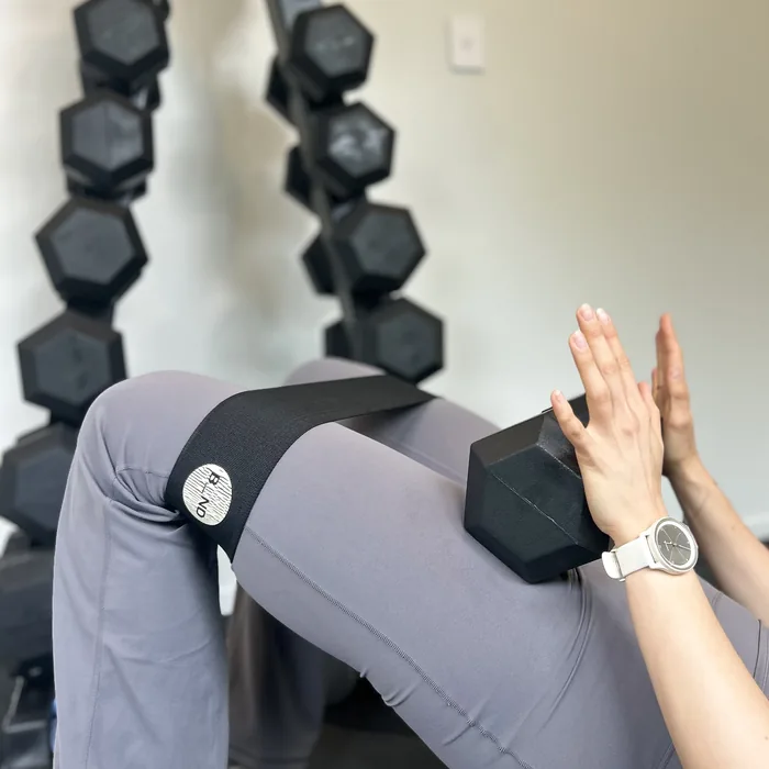 Banded glute bridge with a dumbbell